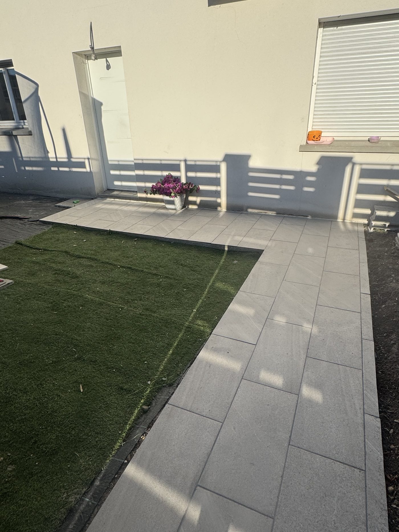 Terrasse extérieure terminée avec carrelage clair le long de la maison